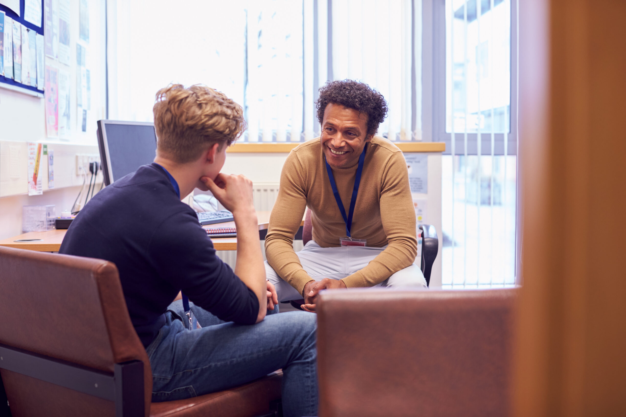 A school counselor speaking with a male student.